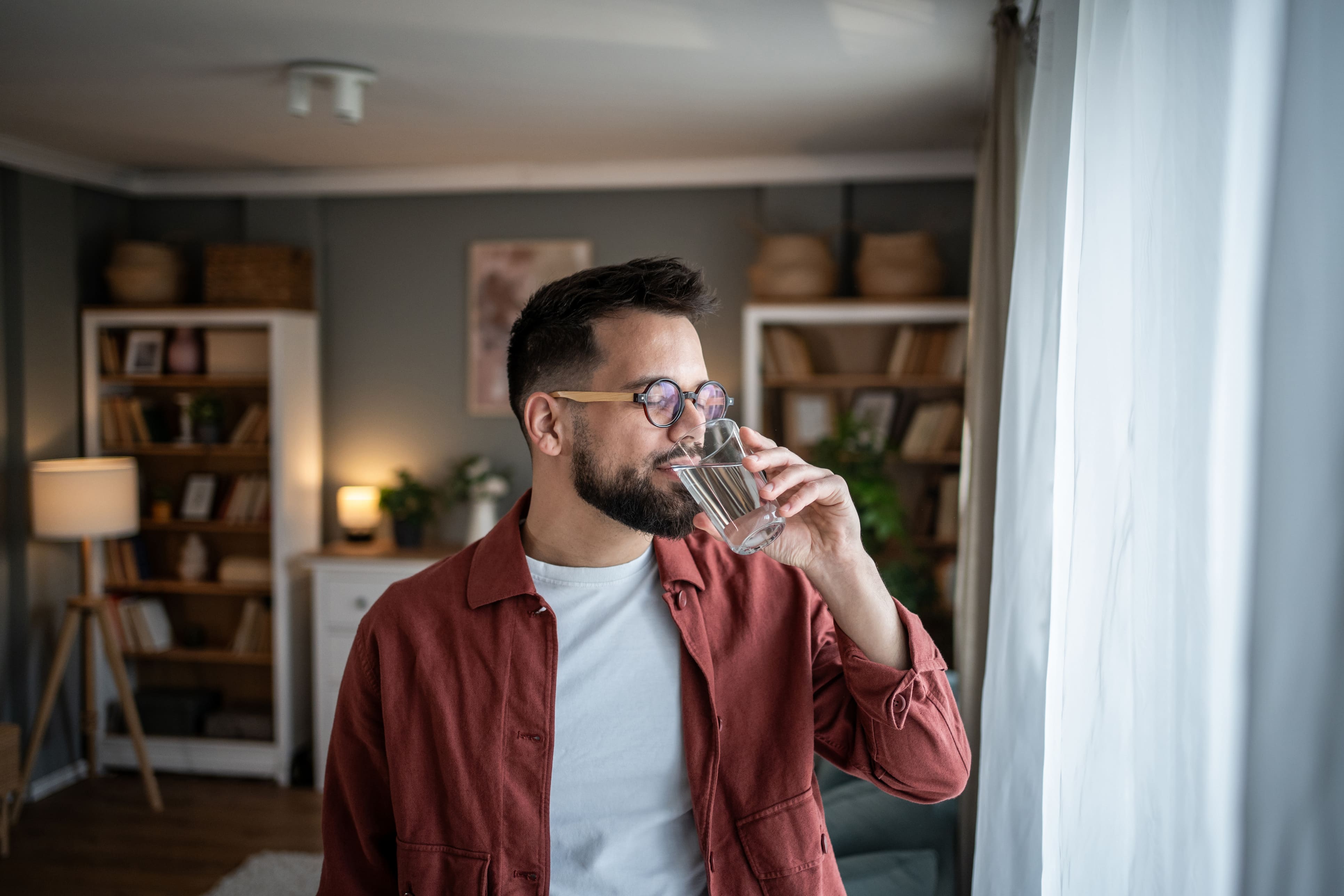 Mann trinkt Wasser aus Glas
